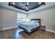 Bedroom with dark ceiling, ceiling fan, hardwood floors, window, and modern decor at 3122 Christophers Watch Ln, Ruskin, FL 33570