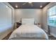 A cozy bedroom with a dark ceiling, ceiling fan, window, closet and white furniture at 3122 Christophers Watch Ln, Ruskin, FL 33570
