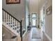 Bright foyer featuring a staircase, coat rack, and tiled floor at 3122 Christophers Watch Ln, Ruskin, FL 33570
