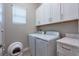 Laundry room featuring a washer and dryer, white cabinets, and gray countertops at 3122 Christophers Watch Ln, Ruskin, FL 33570