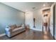 A living room with hardwood floors, sofa, closet, and open entry to hallway at 3122 Christophers Watch Ln, Ruskin, FL 33570