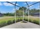 Corner view of a screened-in lanai overlooking the spacious and well-manicured backyard at 3333 Michener Pl, Plant City, FL 33566