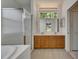 Bathroom with glass-enclosed shower, double sink vanity, and a window above the vanity at 3333 Michener Pl, Plant City, FL 33566