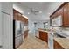 Kitchen with stainless steel appliances, tile backsplash, and brown cabinetry at 3333 Michener Pl, Plant City, FL 33566