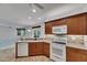 Modern kitchen with white appliances, tile backsplash, and brown cabinetry at 3333 Michener Pl, Plant City, FL 33566