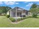 Enclosed screened lanai with ample space for outdoor seating and entertaining, surrounded by manicured landscaping at 3333 Michener Pl, Plant City, FL 33566