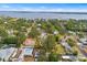 An aerial shot captures a house with a pool, nestled in a green neighborhood, near a beautiful bay at 3417 1St W Ave, Bradenton, FL 34205