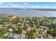 This aerial view showcases the neighborhood's homes and mature trees, situated along a scenic waterway with clear skies above at 3417 1St W Ave, Bradenton, FL 34205