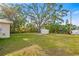 Spacious backyard featuring a storage shed, mature trees, and lush green lawn at 3417 1St W Ave, Bradenton, FL 34205