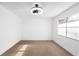 This bedroom features neutral carpeting, bright natural light, and a modern ceiling fan and light at 3417 1St W Ave, Bradenton, FL 34205