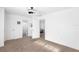 A bright bedroom includes an en-suite bathroom, white walls, a ceiling fan, and neutral carpeting at 3417 1St W Ave, Bradenton, FL 34205