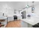 Bright kitchen features stainless steel appliances, white cabinets, light countertops, pendant lights and hardwood flooring at 3417 1St W Ave, Bradenton, FL 34205