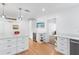 Bright kitchen with stainless steel appliances, wine fridge, white cabinets, light countertops and hardwood flooring at 3417 1St W Ave, Bradenton, FL 34205