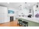 Bright kitchen with stainless steel appliances, wine fridge, white cabinets, light countertops and a center island with stools at 3417 1St W Ave, Bradenton, FL 34205