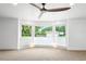 Bright living room with large bay windows offering ample natural light and a modern ceiling fan at 3417 1St W Ave, Bradenton, FL 34205