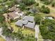 Aerial view of a home with a well-manicured lawn, pool, and mature trees in a quiet neighborhood at 4009 Carrollwood Village Dr, Tampa, FL 33618