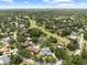 An aerial shot overlooking a neighborhood, a golf course, a pond, and lush green trees at 4009 Carrollwood Village Dr, Tampa, FL 33618