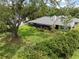Expansive backyard featuring a screened-in lanai, lush greenery, and mature trees for privacy at 4009 Carrollwood Village Dr, Tampa, FL 33618