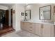 Bathroom featuring double sink vanity with wood cabinets, modern mirrors, and neutral decor at 4009 Carrollwood Village Dr, Tampa, FL 33618