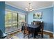Dining room with blue walls, shuttered window, chandelier, and vintage furniture at 4009 Carrollwood Village Dr, Tampa, FL 33618