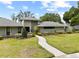 Beautiful home with lush landscaping, a winding walkway and well-manicured lawn at 4009 Carrollwood Village Dr, Tampa, FL 33618