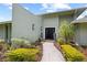 Contemporary home featuring a stucco facade, a black double-door entrance, and vibrant landscaping at 4009 Carrollwood Village Dr, Tampa, FL 33618