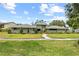 Well-maintained home with lush green lawn, manicured landscaping, and a symmetrical architectural design at 4009 Carrollwood Village Dr, Tampa, FL 33618