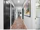 Hallway showcasing brick flooring, black doors, and artistic decor at 4009 Carrollwood Village Dr, Tampa, FL 33618