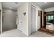 Bright hallway leads to a modern bathroom featuring a tiled shower and a closet for extra storage at 4009 Carrollwood Village Dr, Tampa, FL 33618