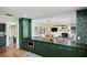 Bright kitchen featuring green cabinetry, bar seating, and an open floor plan at 4009 Carrollwood Village Dr, Tampa, FL 33618
