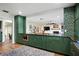 Open kitchen featuring green cabinets, gold hardware, and a view into the living room at 4009 Carrollwood Village Dr, Tampa, FL 33618