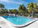 A clean and inviting community pool with lounge chairs and mature landscaping under a beautiful blue sky at 4215 East Bay Dr # 1103D, Clearwater, FL 33764