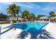 A clean and inviting community pool surrounded by lounge chairs and mature landscaping under a beautiful blue sky at 4215 East Bay Dr # 1103D, Clearwater, FL 33764
