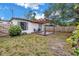 Charming backyard with pergola-covered deck, mature trees, and well-maintained fencing at 4432 W Mccoy St, Tampa, FL 33616