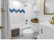 Bathroom with white tile, blue accents, gold fixtures and a patterned shower curtain at 4432 W Mccoy St, Tampa, FL 33616