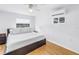 A simple bedroom with minimalist decor, featuring a white bed, bedside tables, and light wood floors at 4432 W Mccoy St, Tampa, FL 33616