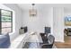 Cozy breakfast nook featuring a built-in bench, modern chandelier, and a stylish geometric accent wall at 4432 W Mccoy St, Tampa, FL 33616