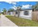 The home's exterior features black-framed windows, planters, and light blue front door at 4432 W Mccoy St, Tampa, FL 33616
