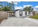 Charming home with covered parking, black framed windows, and white exterior under a blue sky at 4432 W Mccoy St, Tampa, FL 33616