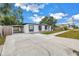 View of the home featuring a carport, black framed windows, and light blue front door at 4432 W Mccoy St, Tampa, FL 33616