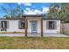 Inviting front entrance with a light blue front door and wood porch columns at 4432 W Mccoy St, Tampa, FL 33616