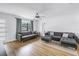 Bright living room featuring a modern gray sofa set, light wood floors, and a ceiling fan at 4432 W Mccoy St, Tampa, FL 33616