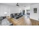 Open-concept living room with gray sofa, adjacent kitchen, and dining area, featuring light wood floors at 4432 W Mccoy St, Tampa, FL 33616