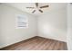 Bright bedroom features a ceiling fan, window, and stylish wood-look flooring at 4681 70Th N Ave, Pinellas Park, FL 33781