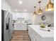 Bright kitchen features white cabinetry, stainless steel appliances, and gold pendant lighting at 4681 70Th N Ave, Pinellas Park, FL 33781