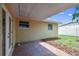 The covered patio with brick flooring, provides a shaded outdoor area, featuring access doors and windows at 5033 Tammy Ln, Holiday, FL 34690
