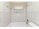 Bathroom with tiled walls and a white bathtub beneath a window at 5033 Tammy Ln, Holiday, FL 34690