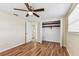 Bright bedroom featuring hardwood floors, a ceiling fan, closet and a window at 5033 Tammy Ln, Holiday, FL 34690