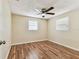 Bedroom featuring hardwood floors, a ceiling fan, and white trim windows at 5033 Tammy Ln, Holiday, FL 34690