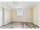 Spacious bedroom features a window and door, complemented by newly installed hard surface floors at 5033 Tammy Ln, Holiday, FL 34690